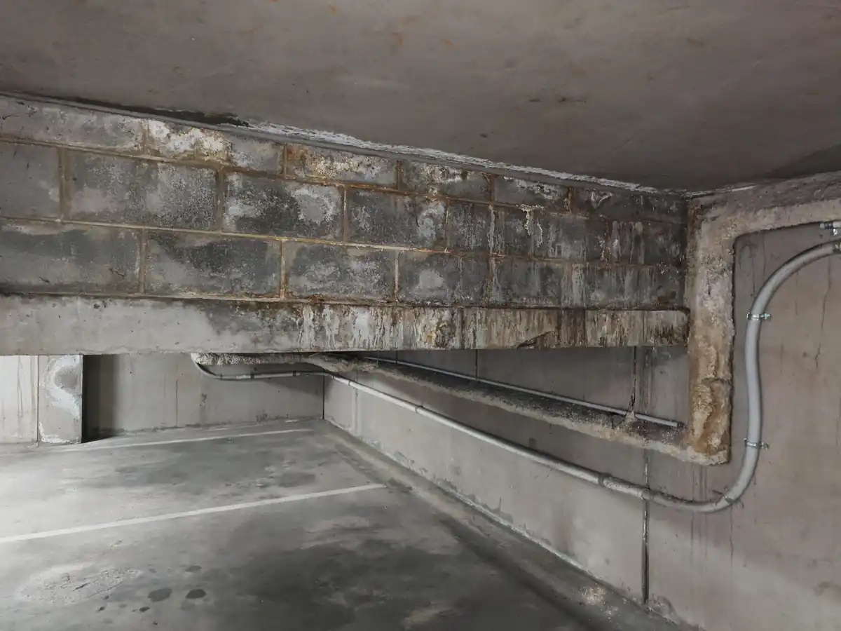 Staining and surface deposits on masonry below a concrete slab.